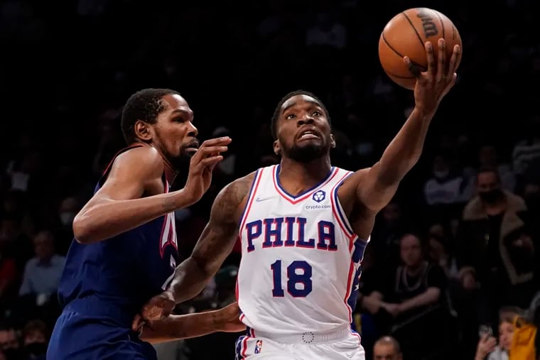Philadelphia 76ers guard Shake Milton (18) goes to the basket against Brooklyn Nets forward Kevin Durant during the first half of an NBA basketball game, Thursday, Dec. 16, 2021, in New York.