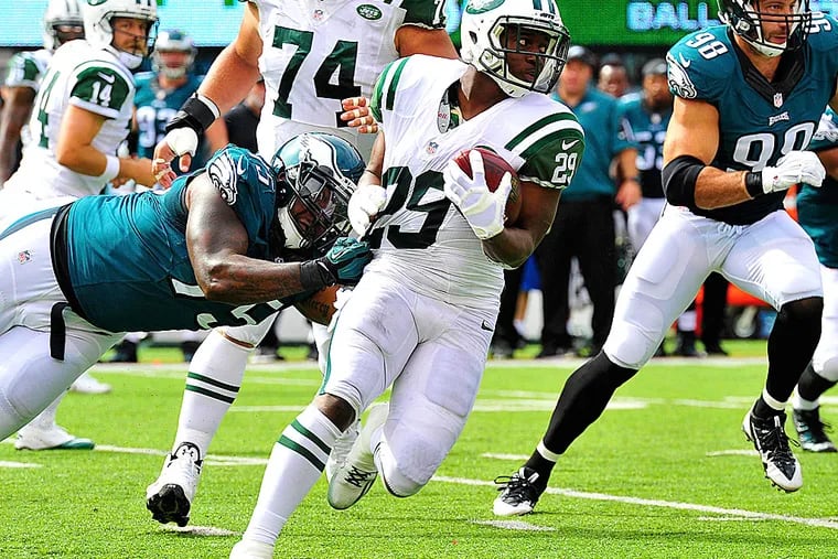 Jets running back Bilal Powell is taken down by Eagles defensive end Vinny Curry.