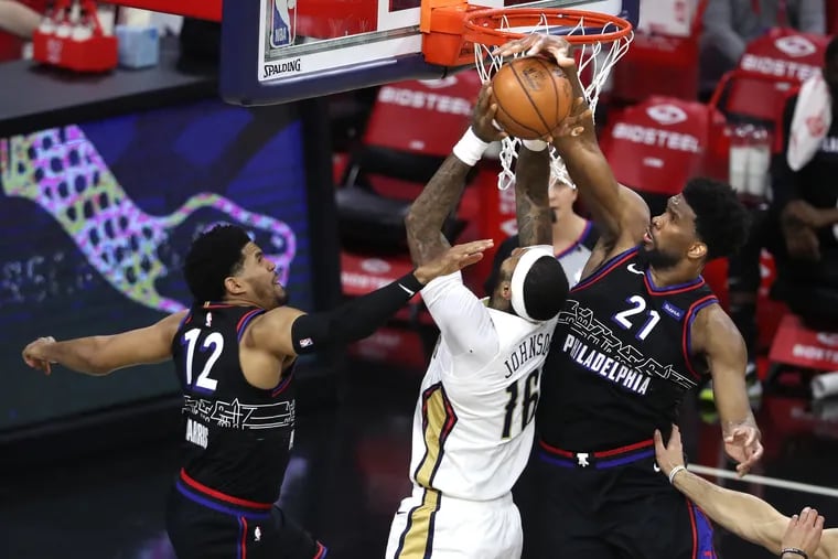 Joel Embiid, right, of the SIxers blocks a shot by James Johnson of the Pelicans during the 2nd half of a NBA game at the Wells Fargo Center on May 7, 2021. Tobias Harris is left.