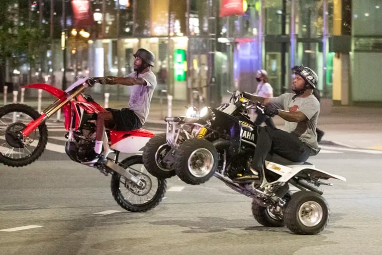 A dirt bike and an ATV rider making their way on 15th Street near Market Street in July 2020.