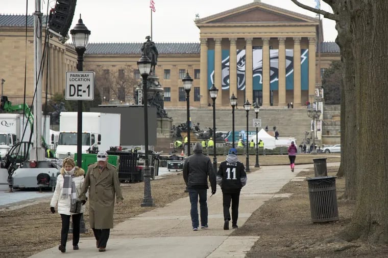 Fans walk down Benjamin Franklin Parkway as the city continues to get ready for the Super Bowl parade. The Philadelphia Museum of Art is among the institutions closing for the celebration.