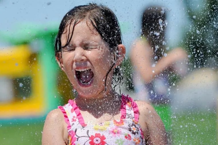 Kayla Holdridge is sprayed with water in an attempt to beat the heat. Philly is about to experience another six or seven day heat wave, marked by high humidity. (AP Photo/The Idaho Press-Tribune, Adam Eschbach)