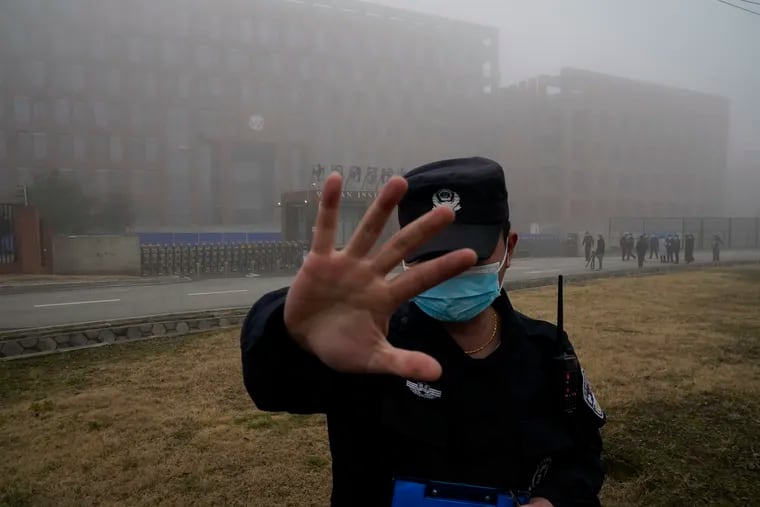 A security person moves journalists away from the Wuhan Institute of Virology after a World Health Organization team arrived for a field visit in Wuhan in China's Hubei province on Feb. 3, 2021.