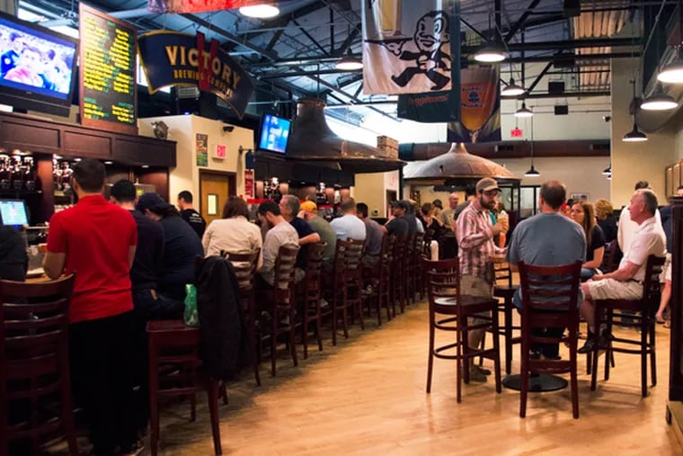 The bar is packed at Victory Brewing Company in Downingtown. Victory, which just recently opened a second brewery in Parkesburg, is planning a new brewpub in Kennett Square this fall and another one in Parkesburg next year. (RACHEL WISNIEWSKI/Staff Photographer)