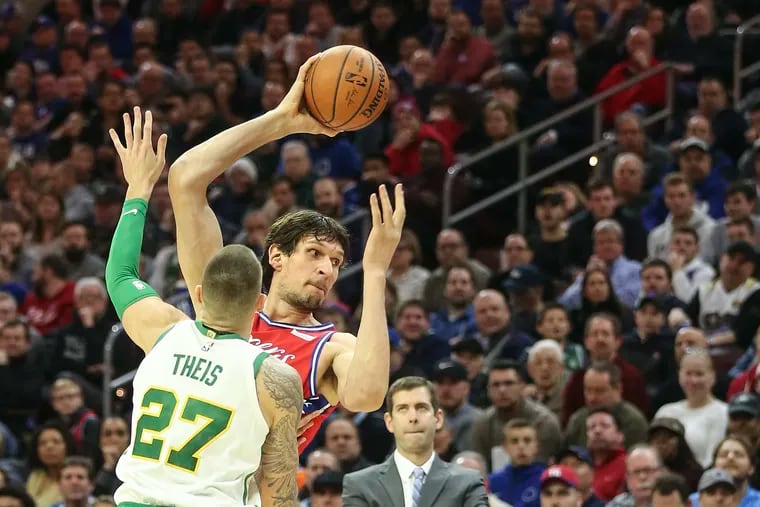 The Sixers' Boban Marjanovic looks to pass over the Celtics' Daniel Theis during the first quarter.