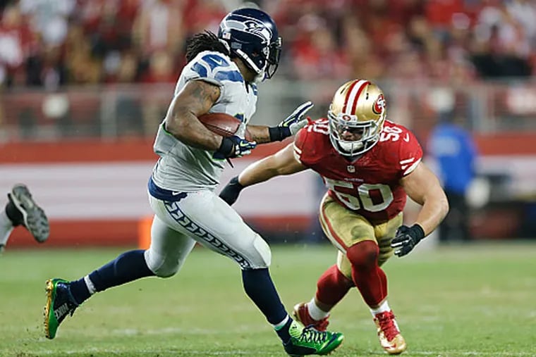 Chris Borland #50 of the San Francisco 49ers tries to tackles Marshawn Lynch #24 of the Seattle Seahawks. (Michael Zagaris/San Francisco 49ers/Getty Images)