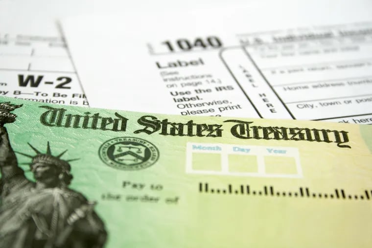 Tax refund check with W-2 and 1040 U.S. Individual Income Tax Return Forms.