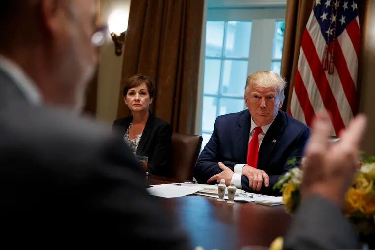 Iowa Gov. Kim Reynolds and President Donald Trump listen as Pennsylvania Gov. Tom Wolf speaks during a meeting with governors on "workforce freedom and mobility" in the Cabinet Room of the White House, Thursday, June 13, 2019, in Washington.