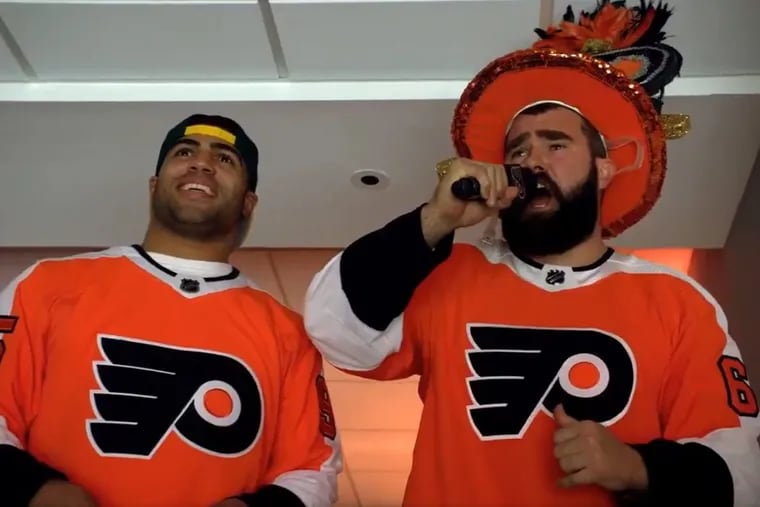 Eagles linebacker Mychal Kendricks (left) and center Jason Kelce lead Flyers fans in a chant during the first intermission of Wednesday night’s 5-2 loss to the Penguins at the Wells Fargo Center.
