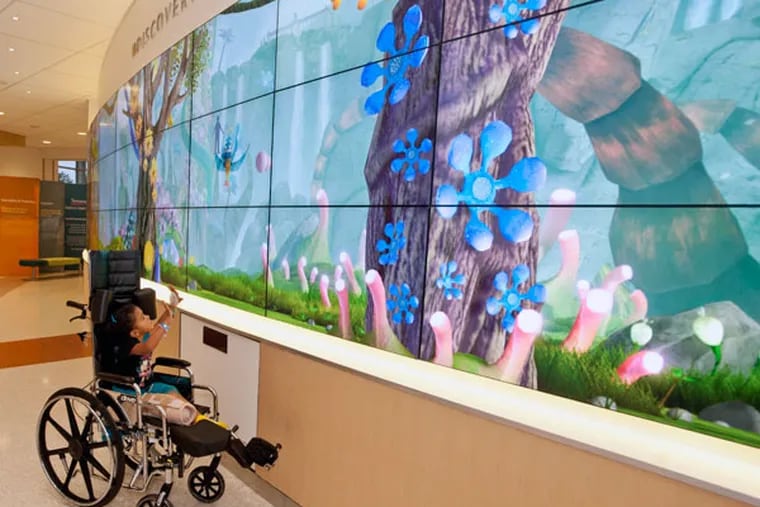 Aaliyah Alley, 4, of Newark, Del., plays in the Discovery Zone in the atrium of the newly expanded Nemours/Alfred I. duPont Hospital for Children in Wilmington. The large screen creates shadowy figures of the person in front. ( RON TARVER / Staff Photographer )