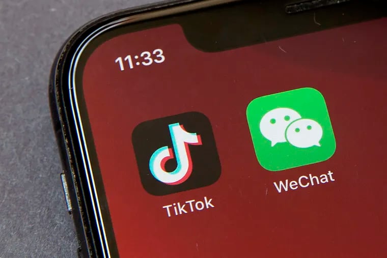 Icons for the smartphone apps TikTok and WeChat are seen on a smartphone screen in Beijing, Friday, Aug. 7, 2020. President Donald Trump has ordered a sweeping but unspecified ban on dealings with the Chinese owners of the consumer apps TikTok and WeChat, although it remains unclear if he has the legal authority to actually ban the apps from the U.S.