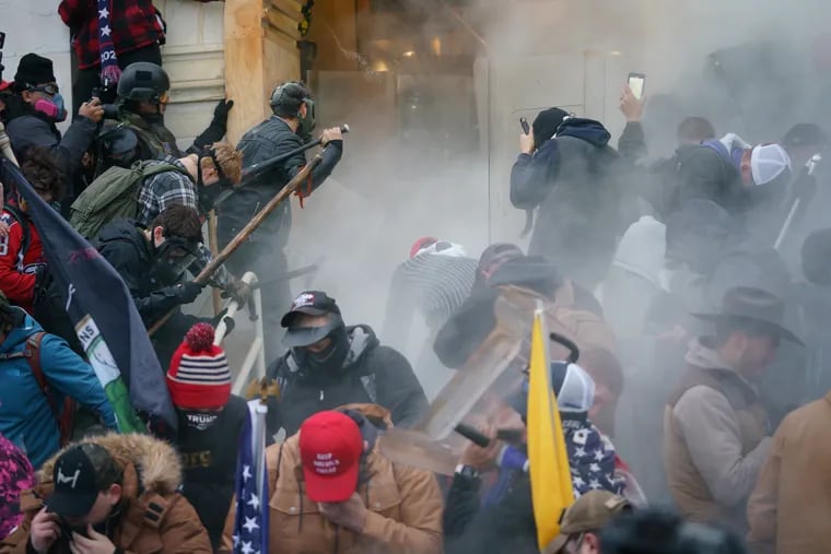 Rioters clash with police to try and gain entrance to a door at the Capitol building on Jan. 6 in Washington.