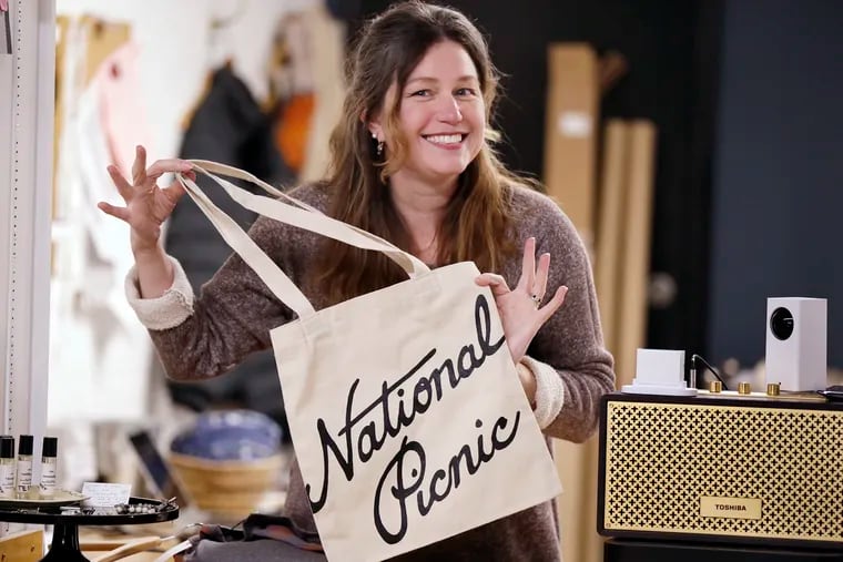 National Picnic Studio Boutique owner/designer Betsy Cook puts a customer purchase in a canvas National Anthem bag that she had made for her grand opening of the shop at 417 Haddon Avenue in Haddonfield on January 18, 2019