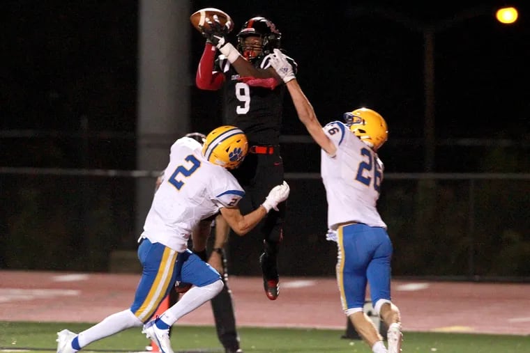 Abdul Sabur Stewart of Coatesville (No. 9) makes a leaping touchdown catch on the final play of the first half vs. Downingtown East on Friday night. Defending for East are Cannon Lucas-Murphy (left) and Bryce Rubino.
