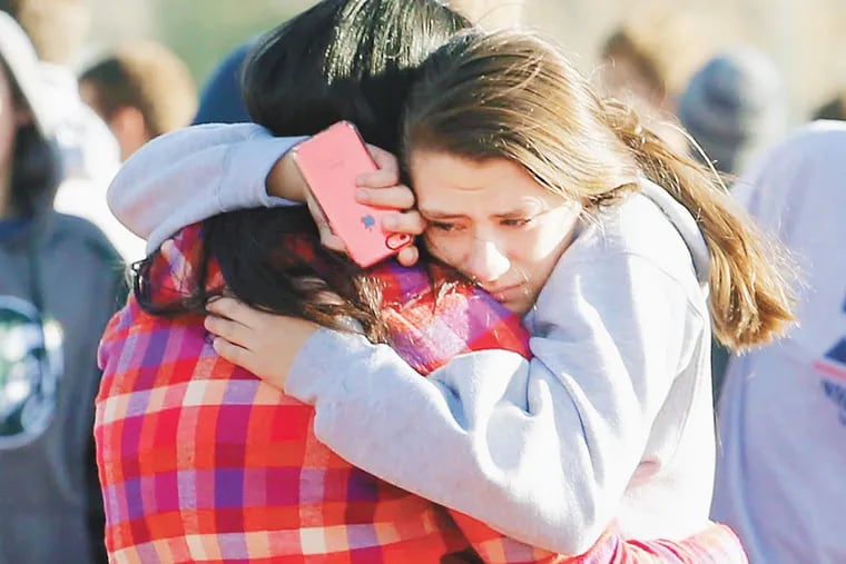 Students comfort each other at Arapahoe High School in Centennial, Colo., on Friday, Dec. 13, 2013.