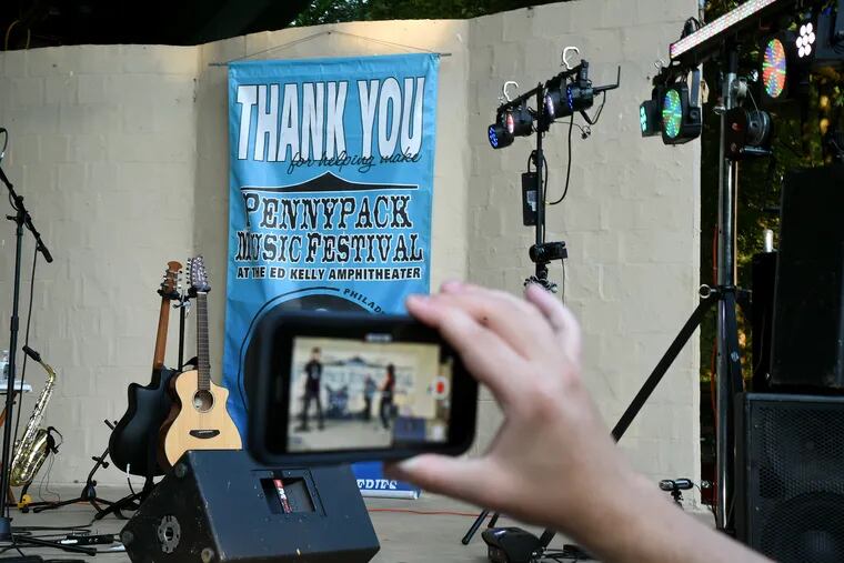A Northeast Philadelphia music lover records video of Starman, a tribute band playing the music of David Bowie as they perform on the Ed Kelly Amphitheater stage during the summer Wednesday night Pennypack Park Music Festival free concert July 24, 2019.