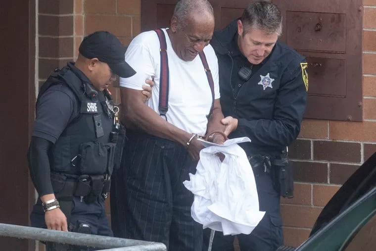Bill Cosby is escorted by police in handcuffs as he exits the Montgomery County Correctional Facility in Norristown last September.