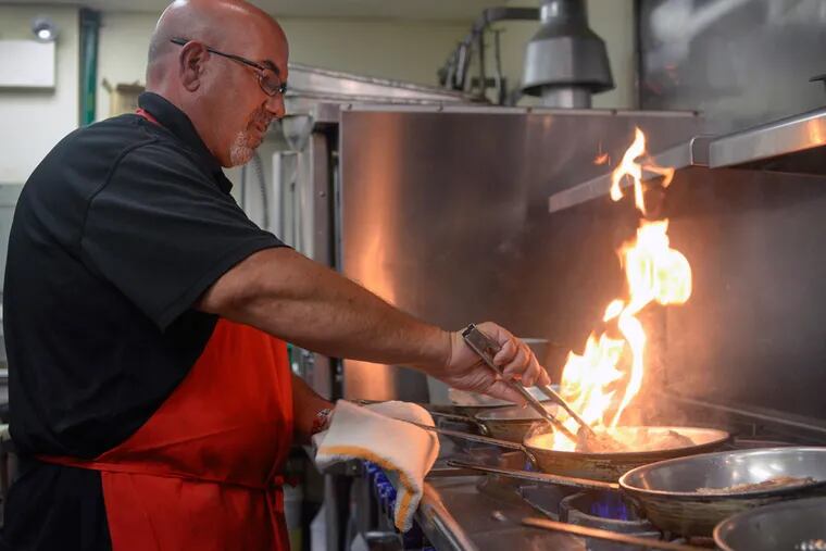 Franco Borda prepares meat for a pizza in the kitchen of Francoluigi's Pizzeria in South Philadelphia. (BEN MIKESELL / Staff Photographer)