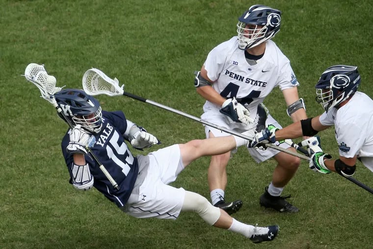 Yale's Jackson Morrill (15) is tripped up by Penn State's Brayden Peck (44) and Penn State's Robby Black (15) during their NCAA men's Division I lacrosse semifinal game at Lincoln Financial Field in South Philadelphia on Saturday, May 25, 2019.