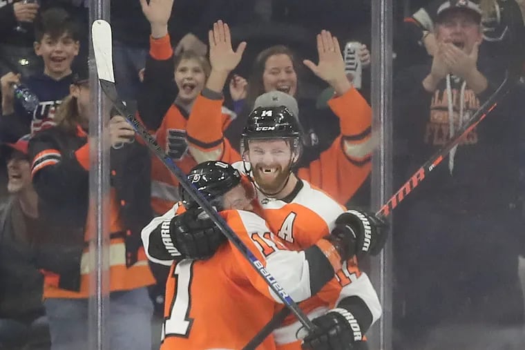 Sean Couturier celebrates his overtime winner with teammate Travis Konecny Thursday night at the Wells Fargo Center.