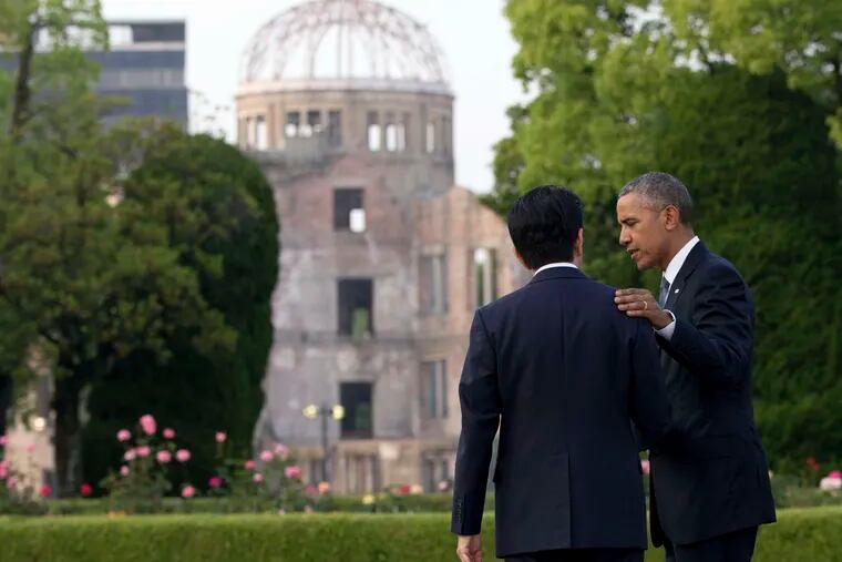 President Obama speaks with Japanese Prime Minister Shinzo Abe, with the Atomic Bomb Dome seen at rear, at the Hiroshima Peace Memorial Park. Obama is the first sitting U.S. president to visit the site.