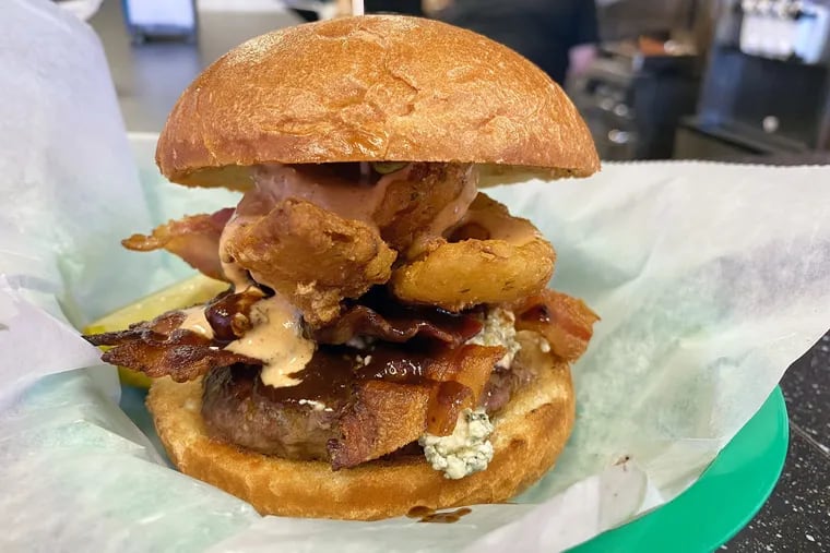 Burgertime NJ's Down Under Burger is a tribute to Outback with blue cheese, bacon, onion petals, A1 sauce, and "blossom sauce."