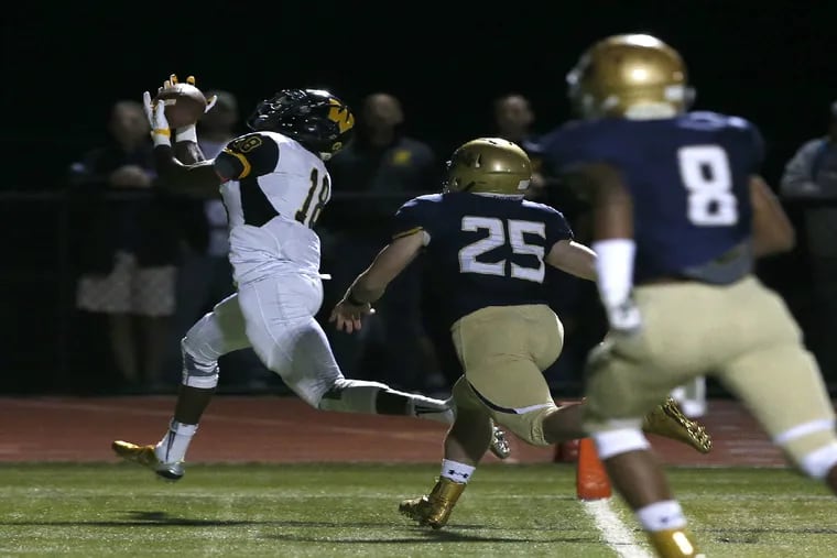 Archbishop Wood's Mark Webb (left) catches a first-quarter touchdown against La Salle's Nick Rinella (center) and Tre McNeill in Catholic League football at Plymouth Whitemarsh on Saturday, October 10, 2015.