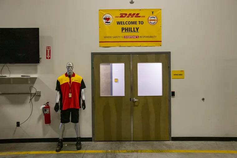 A mannequin in DHL uniform with a sign that reads, "Welcome to Philly" inside the DHL shipping company facility in Sharon Hill, Pa., on October 28, 2021.