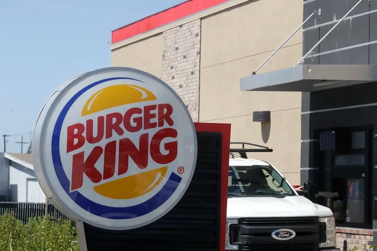 In this Thursday, April 25, 2019, photo a customer takes his order from the drive through window at a Burger King in Redwood City, Calif. Restaurant Brands International, the parent company of Burger King and Tim Hortons, reports financial results on Monday, April 29. (AP Photo/Jeff Chiu)