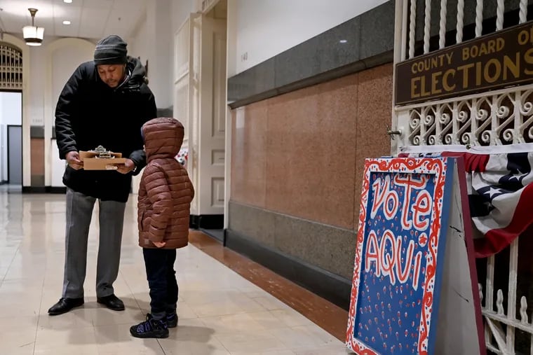 Jeffery Young, who is running to fill the 5th District seat of retiring Philadelphia City Council President Darrell L. Clarke, talks with his 4-year-old son, Parker, after filing his petition at the Board of Elections at City Hall on March 7.