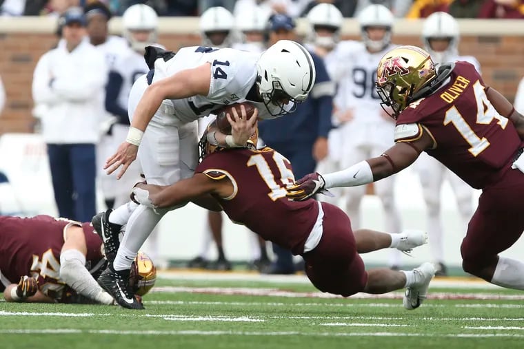 Penn State quarterback Sean Clifford (14) getting tackled by Minnesota defensive back Coney Durr (16) during a Nov. 9 game.