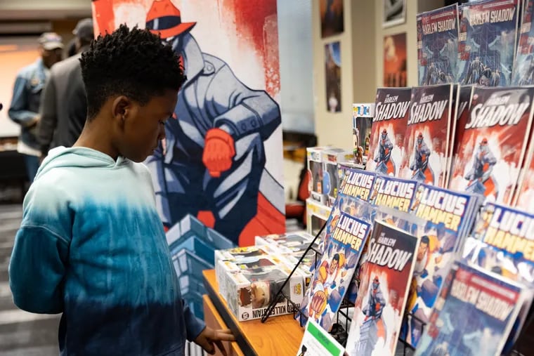 Marris Keene, 8, looks at SoulHammer Comic's booth during the 22nd East Coast Black Age of Comics Convention (ECBACC) at the Temple University Student Faculty Center on May 20, 2023.