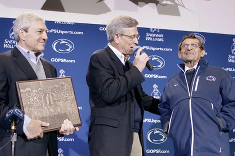 Penn St. athletic director Tim Curley, charged with perjury and failure to report abuse, speaks after Joe Paterno's 409th victory Oct. 29 as university president Graham Spanier waits his turn. (Gene J. Puskar / Associated Press)