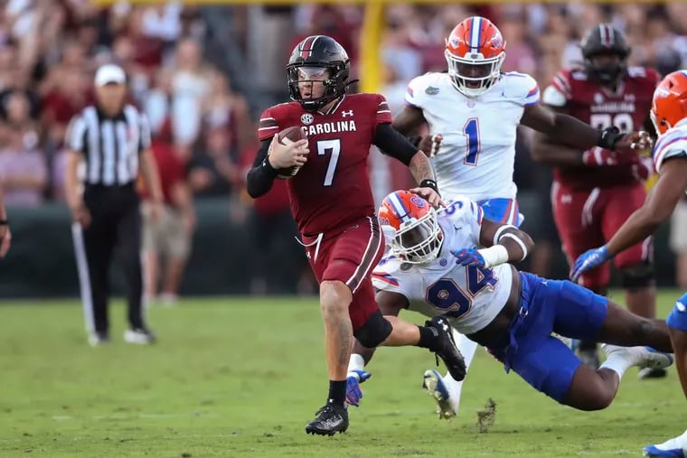 South Carolina quarterback Spencer Rattler (7) runs for a first down past Florida defensive lineman Tyreak Sapp (94) during the second half of an NCAA college football game Saturday, Oct. 14, 2023, in Columbia, S.C. (AP Photo/Artie Walker Jr.)