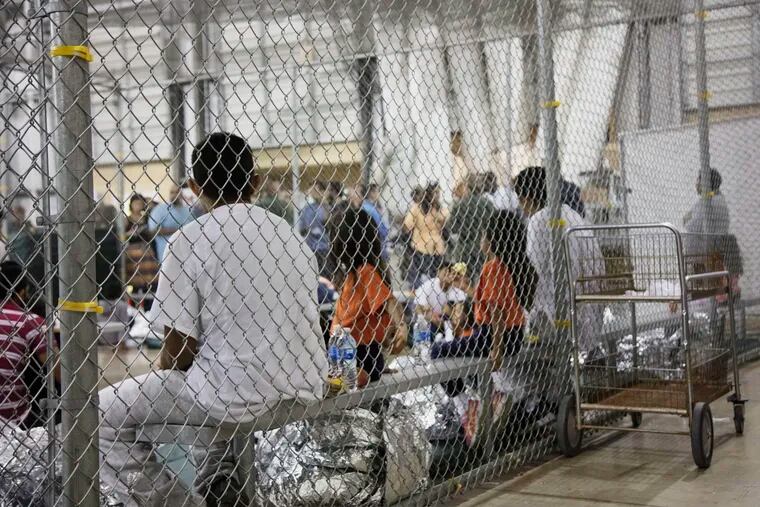 In this June 17, 2018 file photo provided by U.S. Customs and Border Protection, people who've been taken into custody related to cases of illegal entry into the United States, sit in one of the cages at a facility in McAllen, Texas.