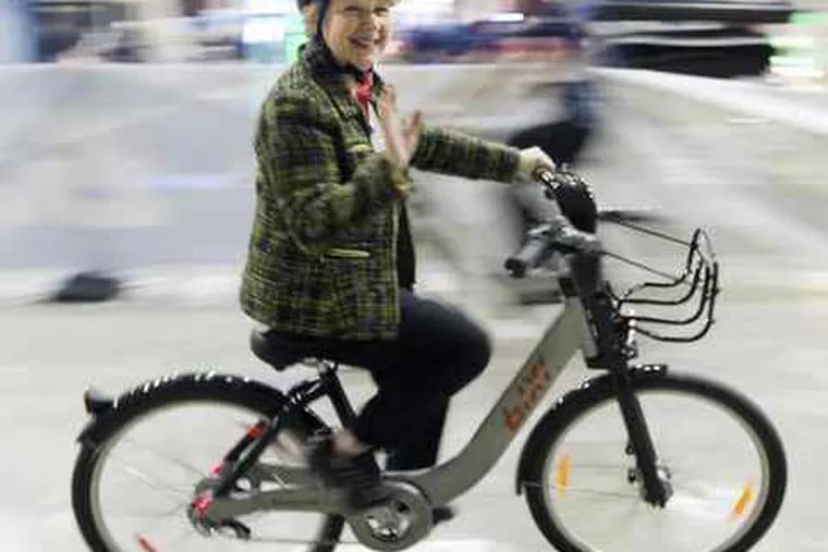 Colette Obre takes a spin on a public bicycle in Montreal. Locally, Philadelphia will open two cross-town bicycle paths today.