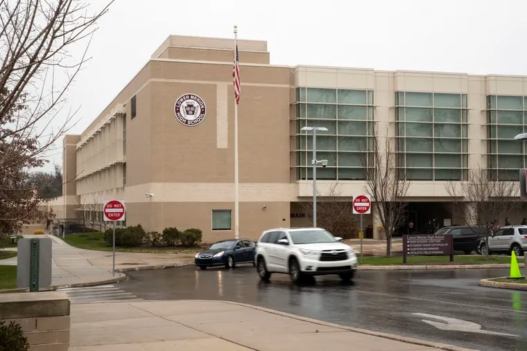 Cars leave Lower Merion High School in Ardmore on Wednesday. Due to operational issues, students at both Harriton and Lower Merion high schools will return to fully virtual instruction from Dec. 14, through Jan. 8.