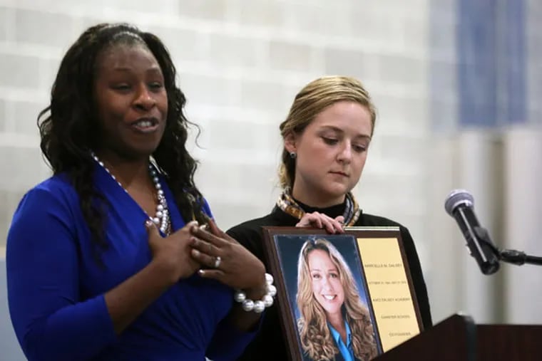 Principal Tishari Landi and Grace Dalsey unveil a portrait of Marcy Dalsey during a re-dedication ceremony at The Katz Academy Charter School in Camden in memory of Marcella Dalsey, who died with school founder Lewis Katz in a plane crash last summer. ( DAVID SWANSON / Staff Photographer )