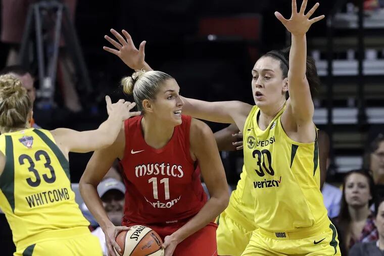 Washington Mystics' Elena Delle Donne (11) looks for room to pass as Seattle Storm's Sami Whitcomb (33) and Breanna Stewart (30) defend in the first half of Game 2 of the WNBA basketball finals Sunday, Sept. 9, 2018, in Seattle. (AP Photo/Elaine Thompson)