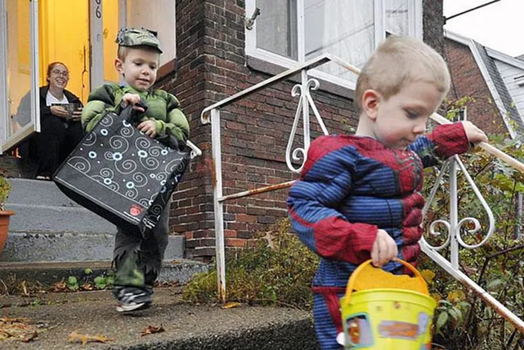 Halloween isn't happening this year at Inglewood Elementary School in Lansdale, where officials say celebrating the holiday could be seen as endorsing a religious belief. Here, twins Liam, as the Hulk, and Garret, as Spiderman, trick-or-treat in Lawrence Park, Pa., on Halloween in 2012. (AP Photo/Erie Times-News, Greg Wohlford)