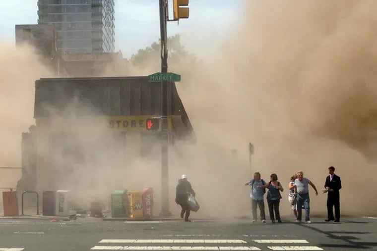 FILE - In this file photo provided by Jordan McLaughlin, a dust cloud rises as people run from the scene of a building collapse on the edge of downtown Philadelphia on Wednesday, June 5, 2013. (AP Photo/Jordan McLaughlin, File)