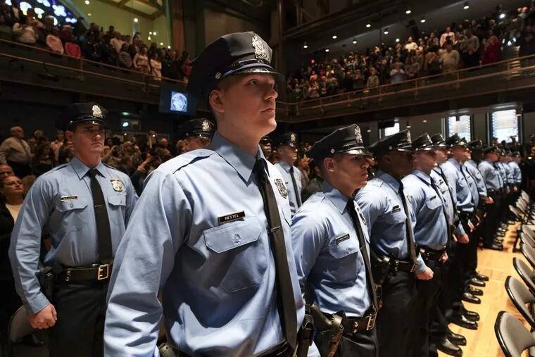 Philadelphia police officers stand at attention during their graduation ceremony last year.