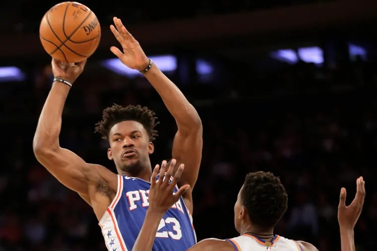 Jimmy Butler passes around the Knicks' Frank Ntilikina during the first half.