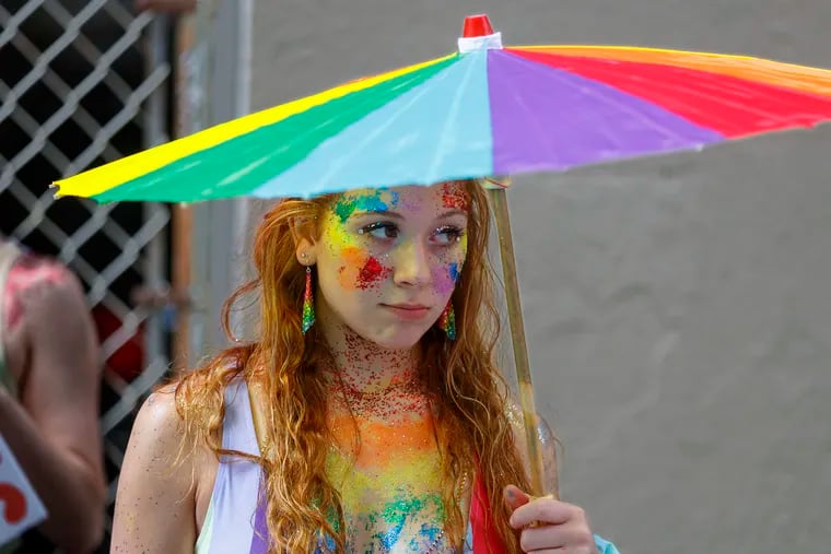 Krystal Cirillo, of Bucks County, holds onto her rainbow umbrella as rain began to fall prior to the start of the parade celebrating Philadelphia's 30th annual PrideDay Sunday.
