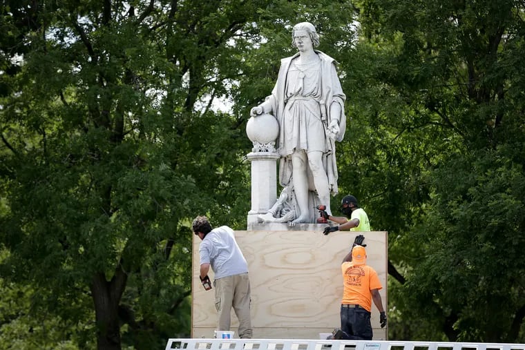 Workers box up the Christopher Columbus statue in Marconi Plaza on Tuesday.
