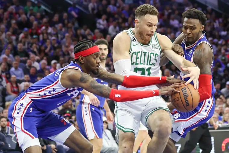 Boston Celtics forward Blake Griffin battles for a rebound with Sixers forwards Jalen McDaniels and Paul Reed in a game at the Wells Fargo Center.