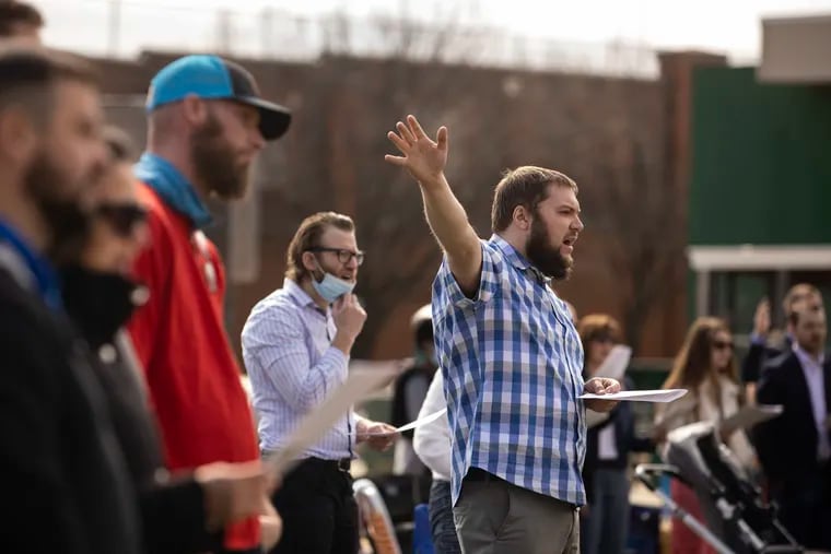 Caleb McCurley sings during the Christ Church Easter Service at the EOM baseball field in South Philadelphia, Pa. on Sunday, April 4, 2021. Christ Church is located a few blocks from the EOM field.