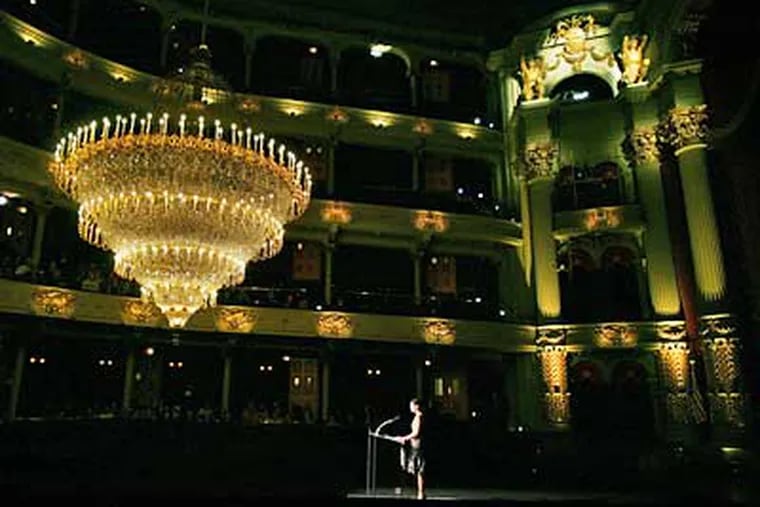 Academy of Music president Jody Lewis is dwarfed by the restored chandalier as she speaks during an unveiling ceremony there. (Eric Mencher/Inquirer)