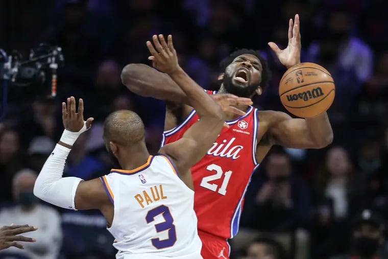 Sixers Joel Embiid is fouled by the Suns' Chris Paul during the first quarter at the Wells Fargo Center.