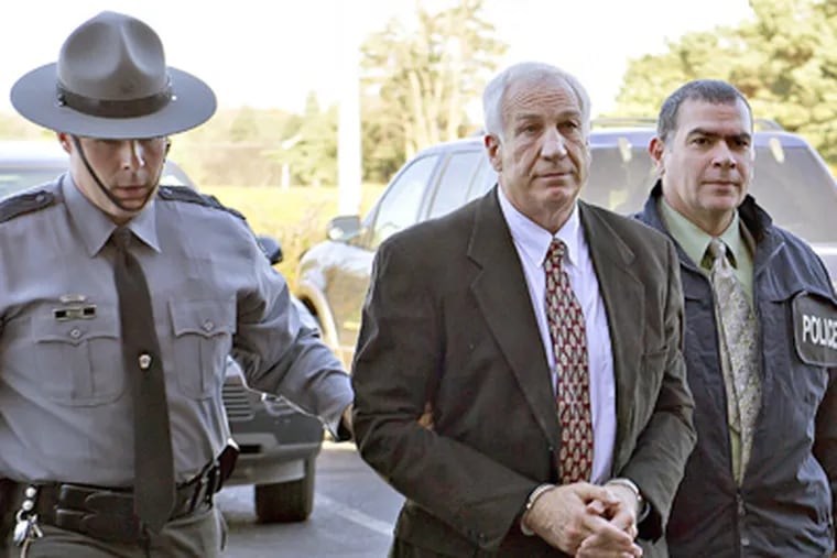 Former Penn State defensive coordinator Jerry Sandusky with police in November after being charged with sexually abusing eight boys. (Andy Colwell / The Patriot-News)